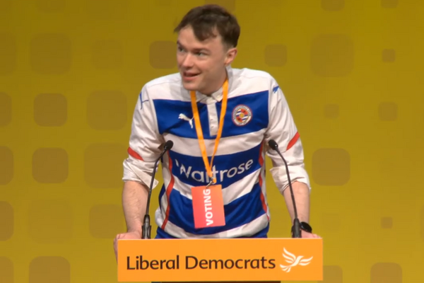 Henry Wright speaks at the Lib Dem Spring Conference wearing a Reading FC strip