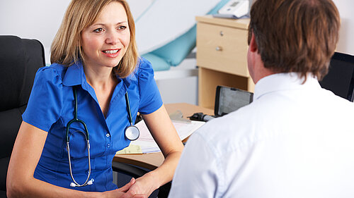 A nurse speaking to a patient.